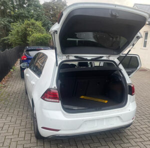 Rear view of a white hatchback car with the boot open